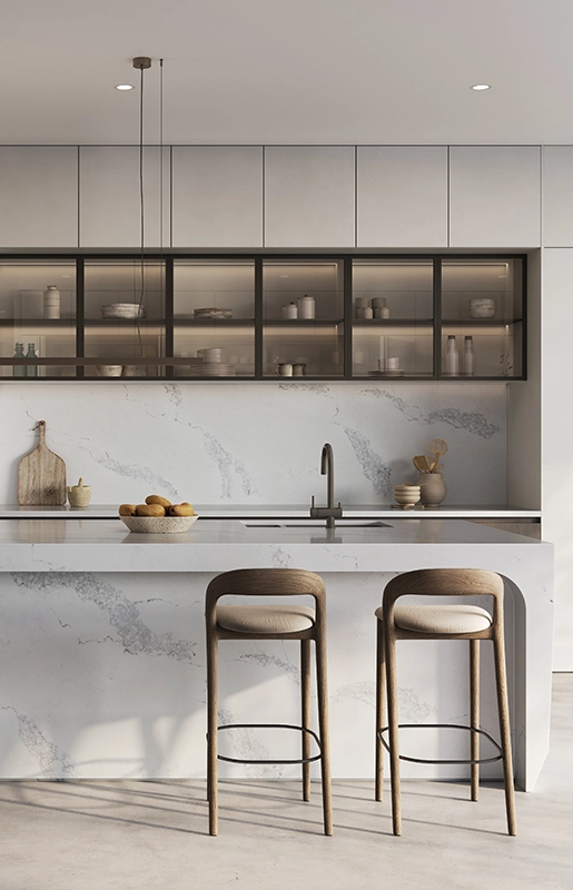 Modern kitchen with marble island, two bar stools, upper glass cabinets, and minimalist decor.