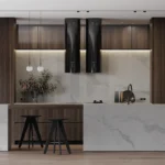 Modern kitchen with marble island, dark wood cabinets, black stools, and minimalist pendant lights.