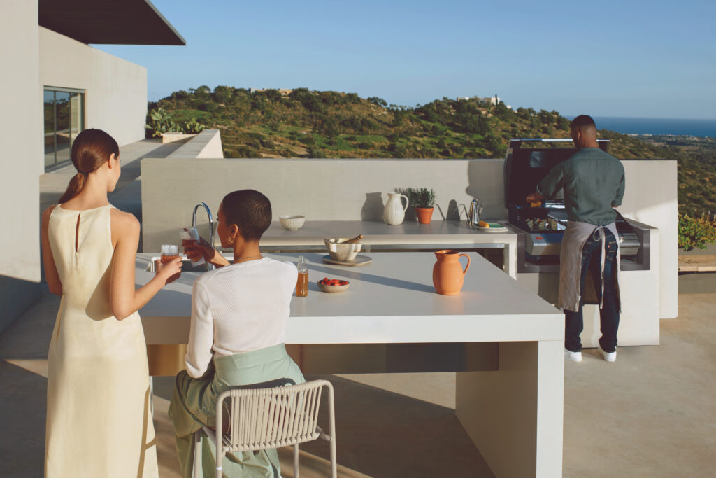 People enjoying outdoor grill with white countertops and island 