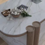 Caesarstone porcelain 506 Mirabel surface in Marble kitchen island with mushrooms, herbs, wooden cutting board, and two wooden stools.