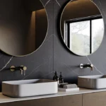 Modern bathroom with dark walls, two round mirrors, rectangular sinks, and wooden cabinetry.