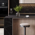 Modern kitchen with black Porcelaon 511 Smokestone island, wooden cabinetry, two stools, coffee machine, and plant centerpiece.