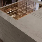 Caesarstone porcelain 513 Striata island featuring a glass display case with wooden wine rack compartments, plant nearby in a Modern Fashion Store