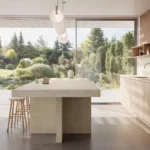 Modern kitchen with large Caesarstone ICON 8252 Sedara island, wooden stools, minimalist cabinetry, and garden view through glass doors.