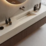 Modern bathroom Cearstone 8252 Sedara sink with integrated basin, wooden vanity, round mirror, and grooming accessories.